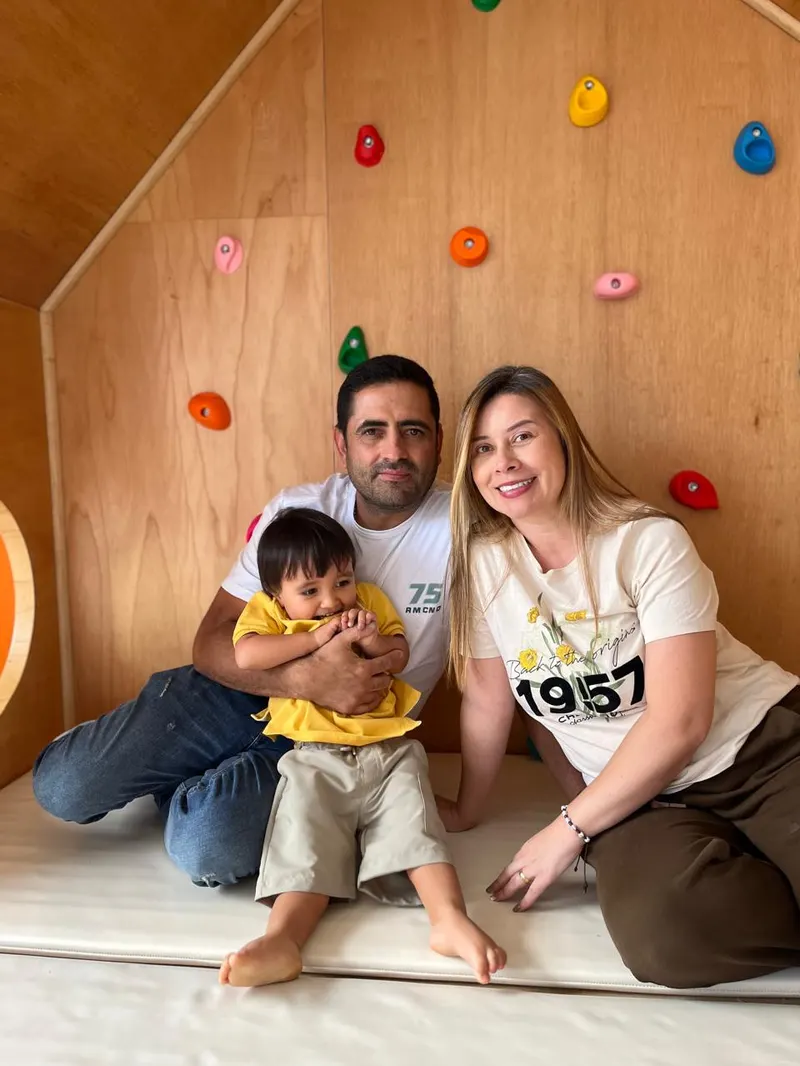 Familia acompañando a su hijo frente al muro de escalada