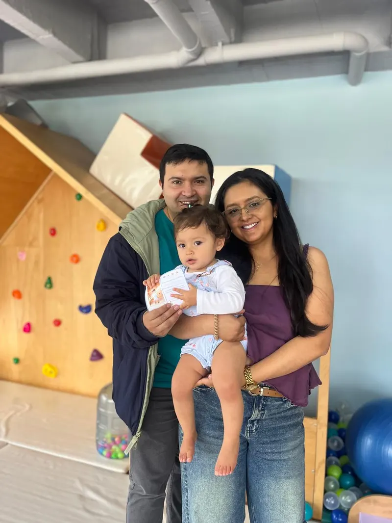 Mamá y papá sosteniendo a su bebé en el aula de Wawa