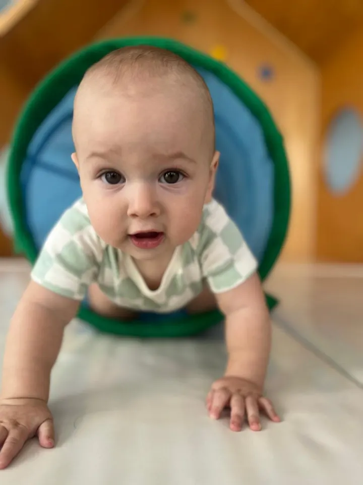 Bebé gateando a través de un túnel de tela
