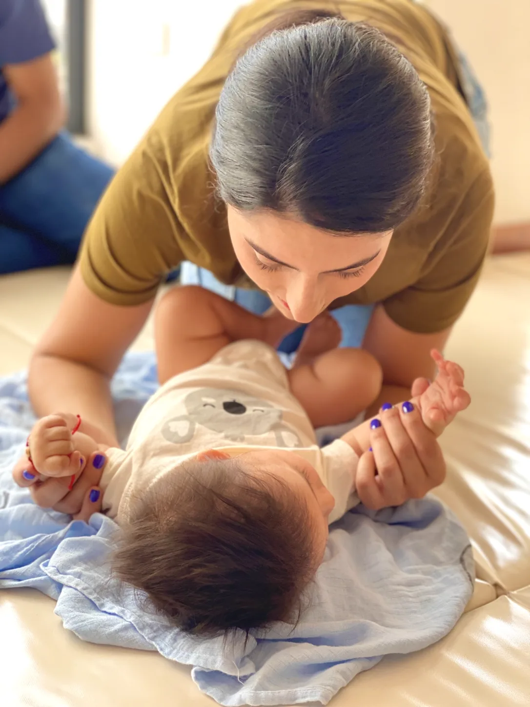 Mamá acompañando con las manos a su bebé recostado durante una experiencia en Wawa
